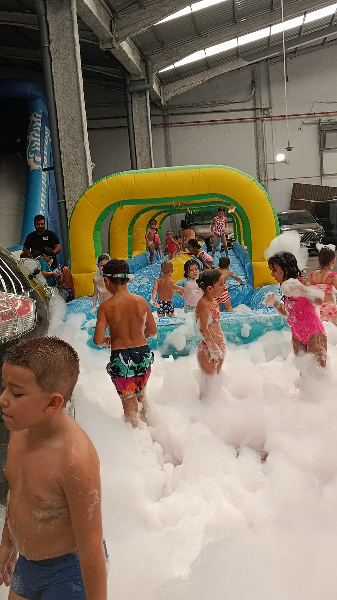 Tobogan de agua rodeado de espuma en una fiesta infantil